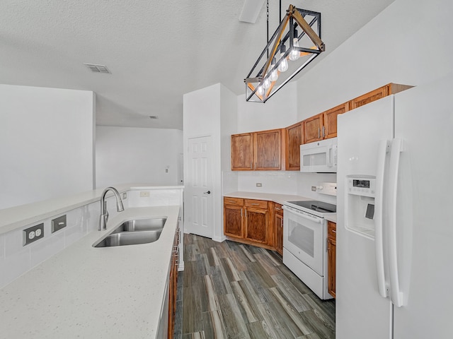 kitchen featuring a textured ceiling, dark hardwood / wood-style floors, sink, hanging light fixtures, and white appliances