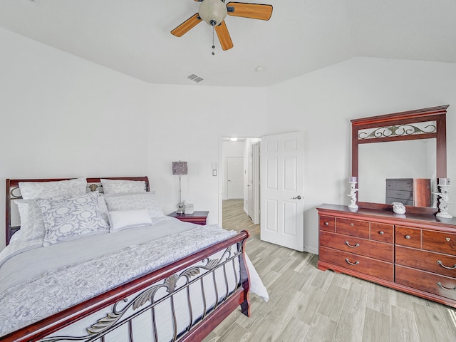 bedroom with ceiling fan, light wood-type flooring, and vaulted ceiling