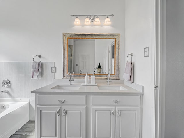 bathroom featuring wood-type flooring, a washtub, and vanity