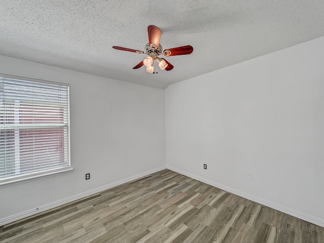 empty room featuring ceiling fan, a textured ceiling, and light hardwood / wood-style floors