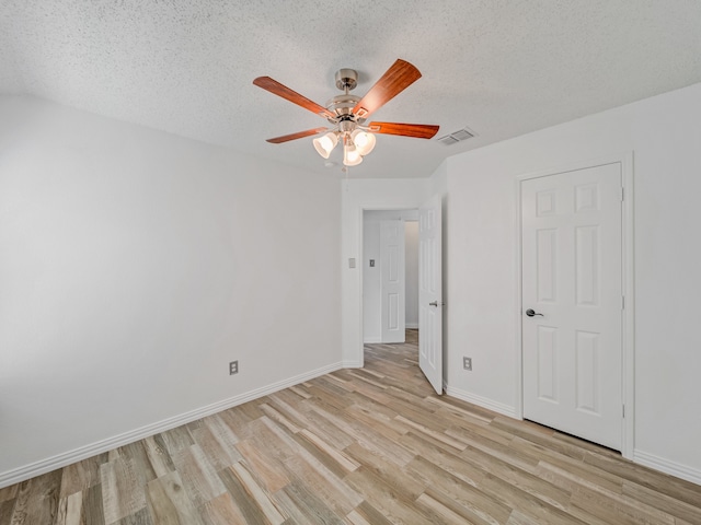 unfurnished room with light wood-type flooring, a textured ceiling, and ceiling fan