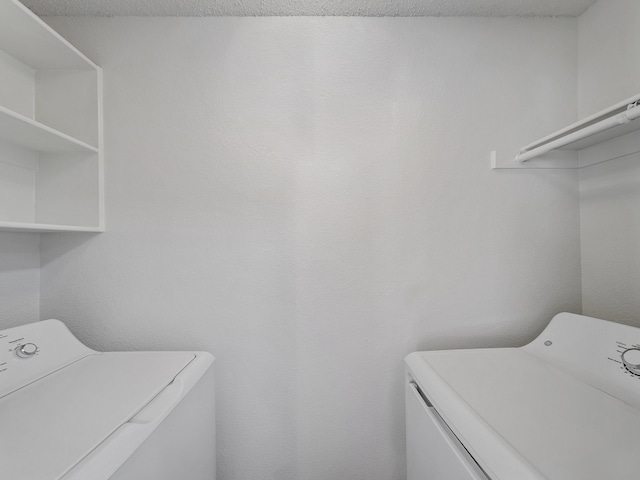 laundry area featuring a textured ceiling and washer and clothes dryer