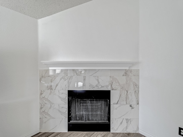 details with a textured ceiling, a fireplace, and hardwood / wood-style flooring