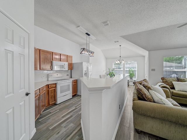 kitchen featuring light hardwood / wood-style floors, white appliances, vaulted ceiling, and decorative light fixtures