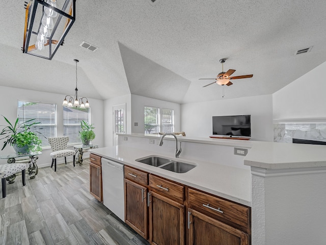 kitchen with light hardwood / wood-style floors, sink, ceiling fan with notable chandelier, vaulted ceiling, and white dishwasher