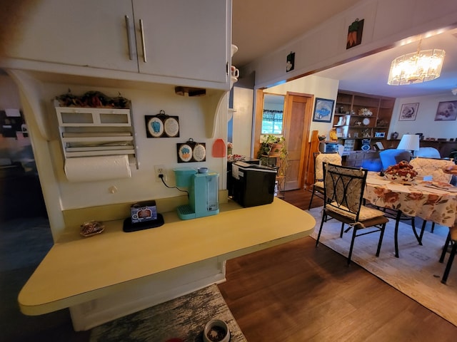 dining room with dark wood-type flooring and a notable chandelier