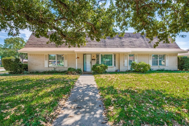 single story home featuring covered porch and a front yard