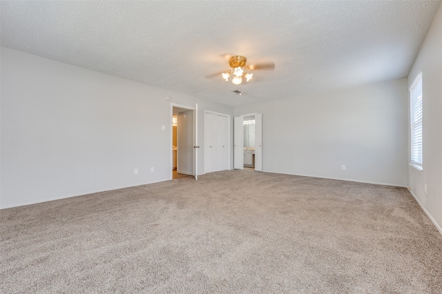 empty room featuring a textured ceiling and carpet flooring