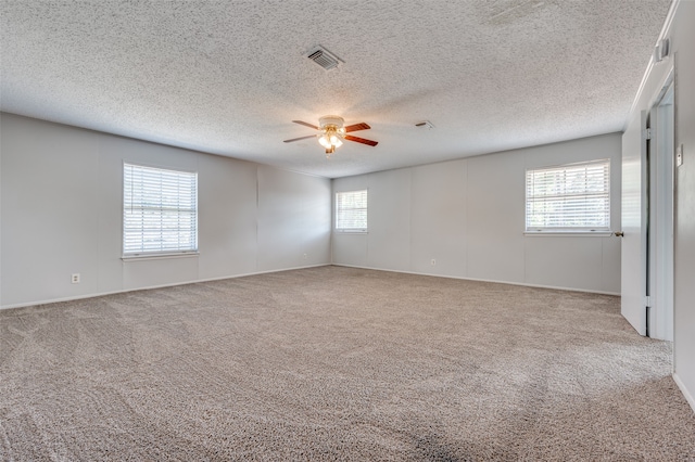 spare room with ceiling fan, light colored carpet, and a textured ceiling