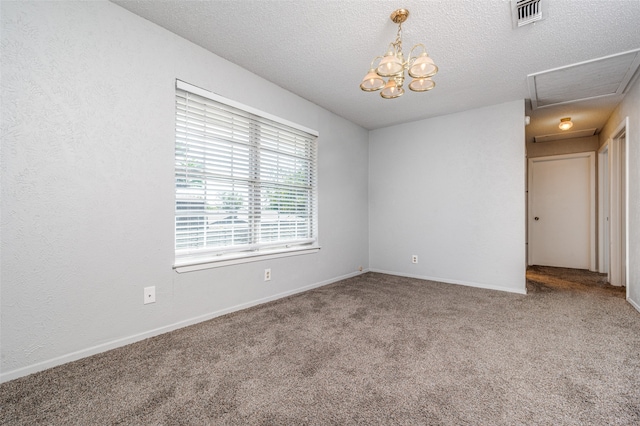 spare room featuring an inviting chandelier, a textured ceiling, and carpet flooring