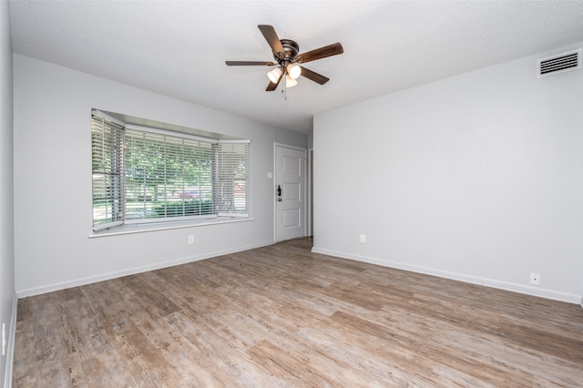 unfurnished room featuring light wood-type flooring, a textured ceiling, and ceiling fan