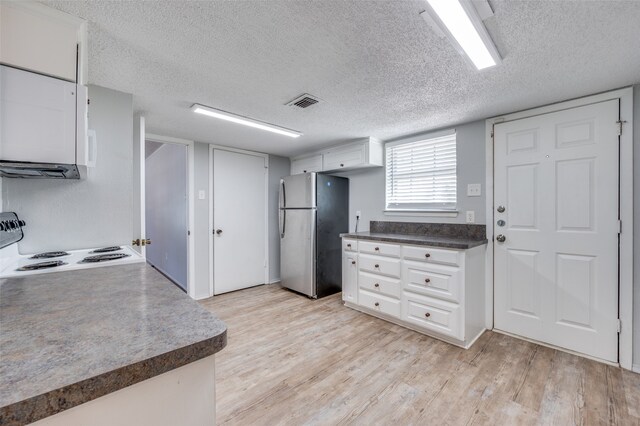 kitchen featuring a textured ceiling, stainless steel fridge, and light hardwood / wood-style floors