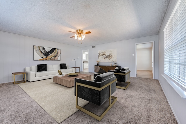 living room with a textured ceiling, carpet flooring, and a wealth of natural light