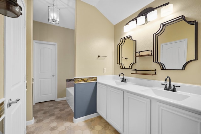 bathroom with a tub to relax in, vanity, and lofted ceiling