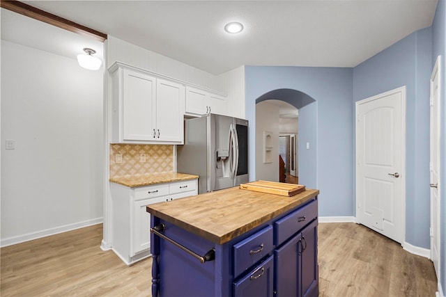 kitchen with wooden counters, white cabinetry, stainless steel refrigerator with ice dispenser, blue cabinets, and a center island