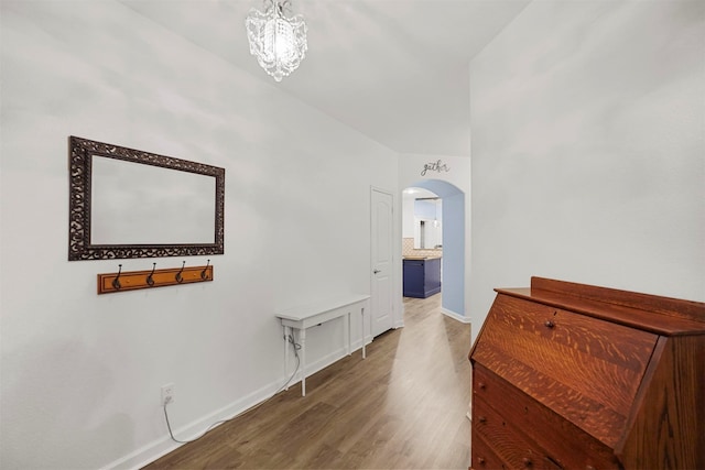 hall with an inviting chandelier and wood-type flooring