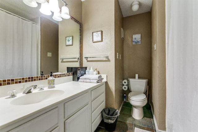 bathroom with vanity, toilet, and a textured ceiling