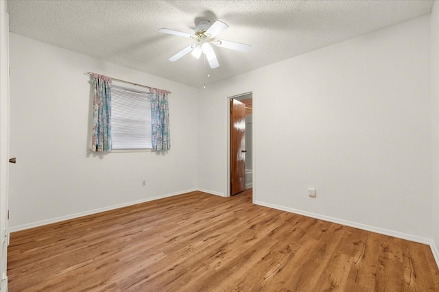 empty room with ceiling fan, a textured ceiling, and light hardwood / wood-style floors