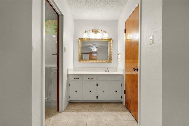 bathroom with tile patterned flooring, ceiling fan, vanity, and a textured ceiling