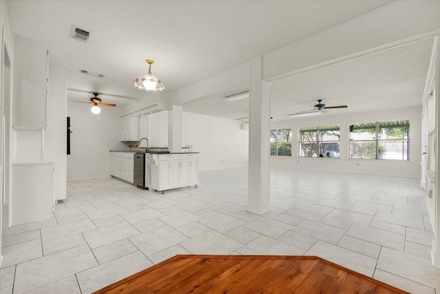 unfurnished living room featuring light tile patterned flooring, sink, and ceiling fan