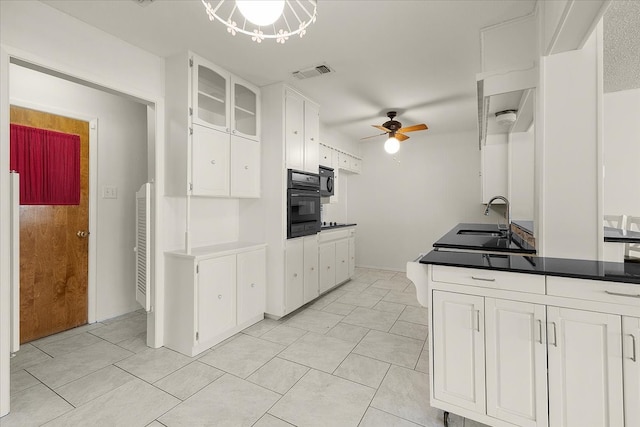 kitchen with black appliances, ceiling fan with notable chandelier, sink, and white cabinetry