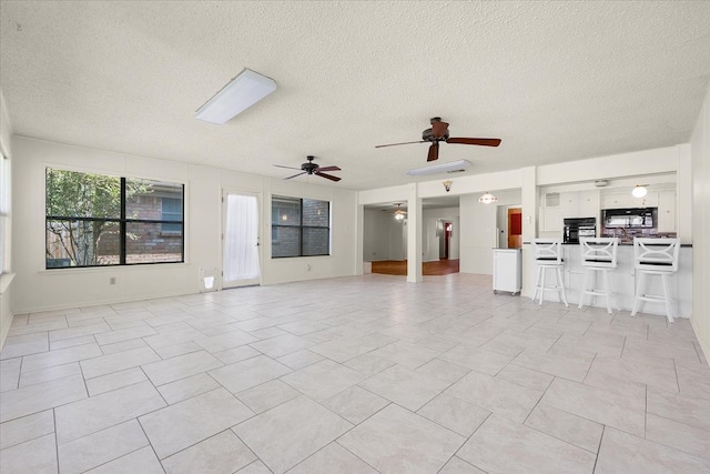 unfurnished living room featuring a textured ceiling and light tile patterned floors