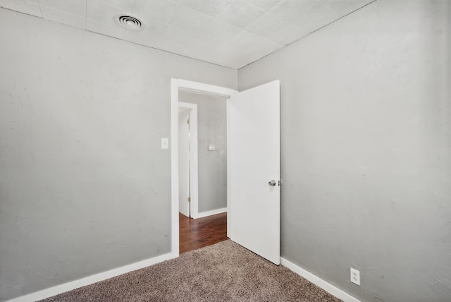 unfurnished room with dark colored carpet