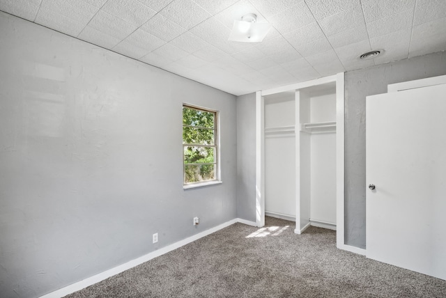 unfurnished bedroom featuring carpet flooring and a closet