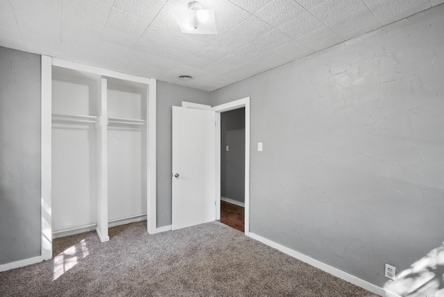 unfurnished bedroom with a closet and carpet flooring