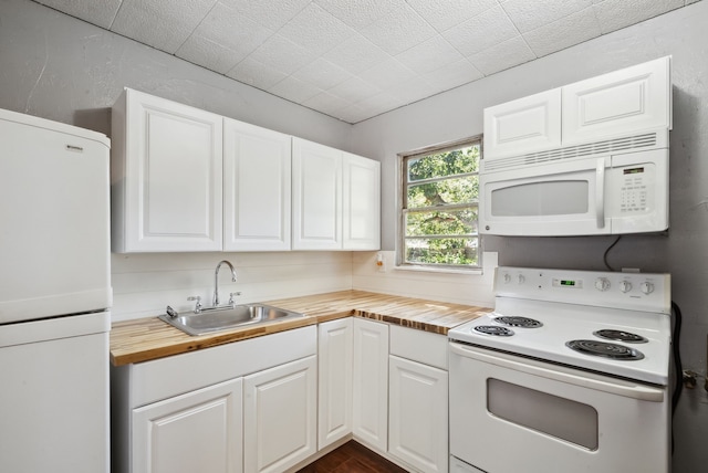 kitchen featuring white appliances, white cabinetry, sink, and wooden counters