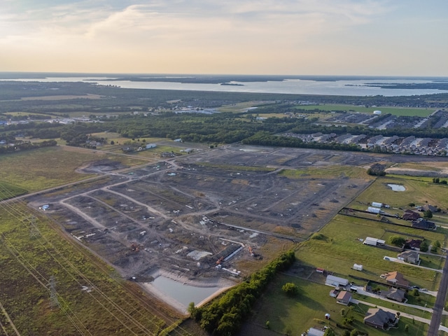 aerial view at dusk featuring a water view