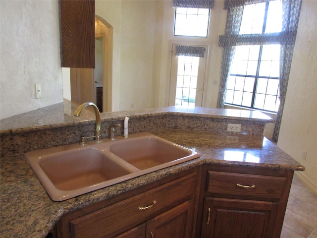 kitchen with sink, kitchen peninsula, and a wealth of natural light