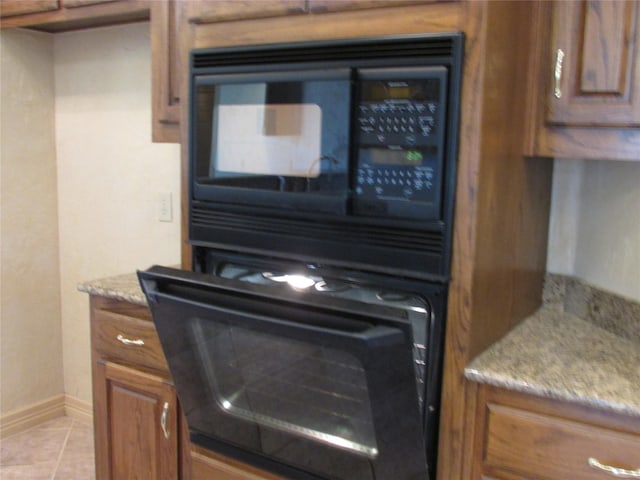 interior details with black appliances and light stone countertops