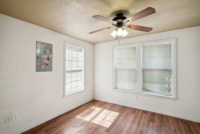 spare room with a textured ceiling, light hardwood / wood-style floors, and ceiling fan