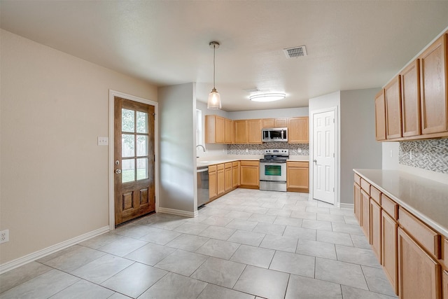 kitchen with pendant lighting, light brown cabinets, sink, tasteful backsplash, and stainless steel appliances