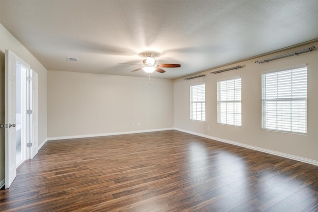 spare room with ceiling fan, a textured ceiling, and dark hardwood / wood-style flooring