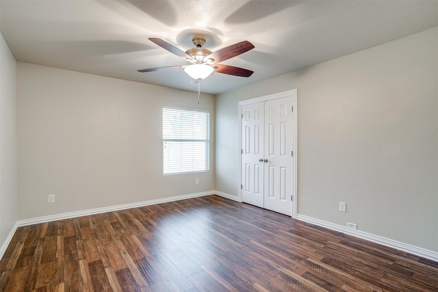 empty room featuring a textured ceiling, dark hardwood / wood-style flooring, and ceiling fan