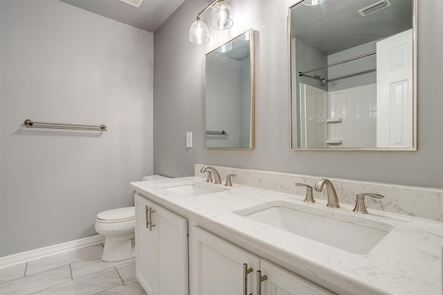 bathroom with a shower, vanity, and toilet