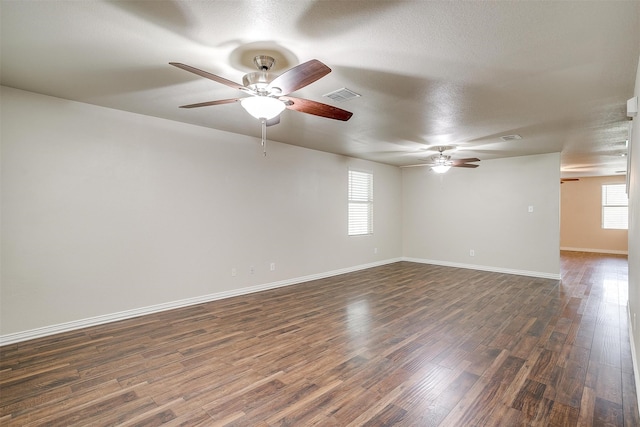 empty room with ceiling fan, a textured ceiling, and dark wood-type flooring