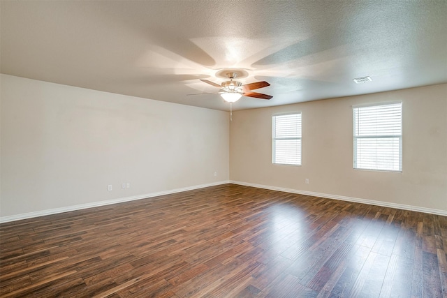 empty room featuring ceiling fan, a textured ceiling, and dark wood-type flooring