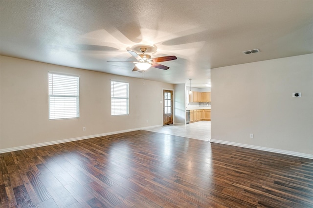 interior space featuring ceiling fan, a textured ceiling, and dark hardwood / wood-style floors