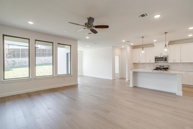 unfurnished living room featuring light hardwood / wood-style flooring and ceiling fan