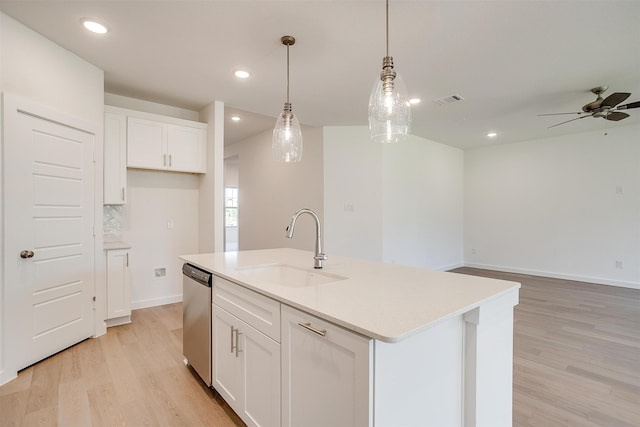 kitchen featuring white cabinetry, sink, stainless steel dishwasher, and a center island with sink