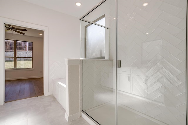 bathroom featuring ceiling fan, wood-type flooring, and separate shower and tub