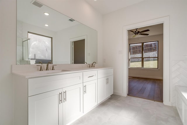 bathroom with vanity, hardwood / wood-style floors, plus walk in shower, and ceiling fan