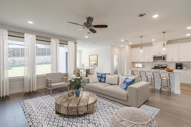 living room featuring ceiling fan and light hardwood / wood-style flooring