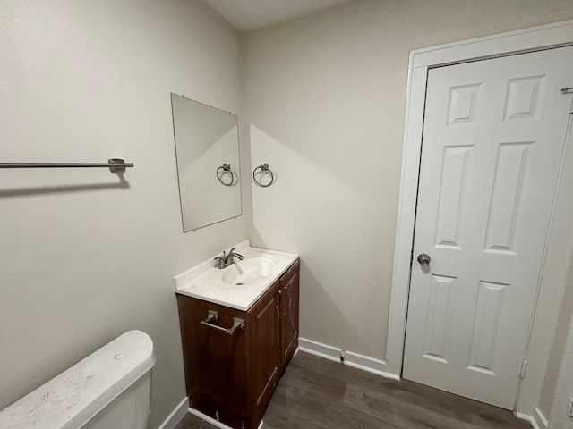 bathroom with vanity, toilet, and hardwood / wood-style flooring