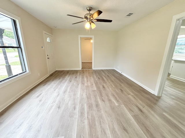 spare room with ceiling fan, a textured ceiling, and light hardwood / wood-style floors