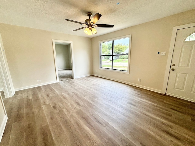 empty room featuring a textured ceiling, hardwood / wood-style floors, and ceiling fan