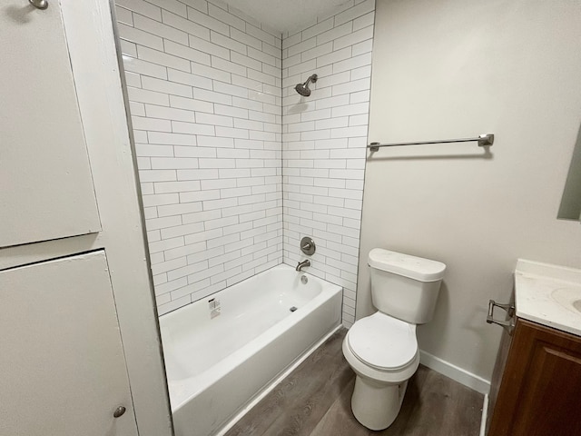 full bathroom with hardwood / wood-style floors, vanity, toilet, and tiled shower / bath